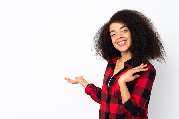 Giovane donna afroamericana che estende le mani al lato per invitare a venire