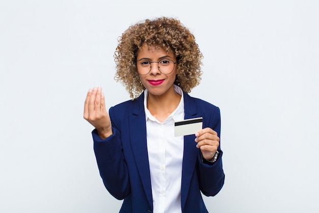 Giovane donna afroamericana che fa gesto di capice e che tiene una carta di credito