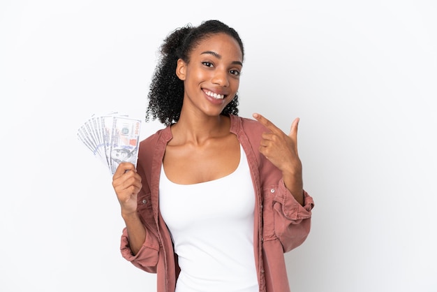 Giovane donna afroamericana che prende molti soldi isolata su fondo bianco che dà un gesto di pollice in alto