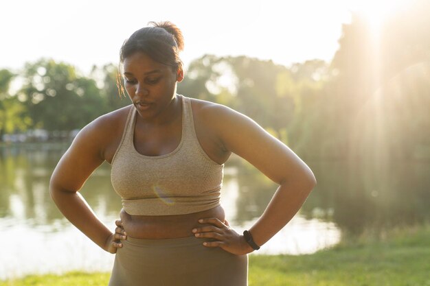 Giovane donna afroamericana che respira dopo un duro allenamento nel parco