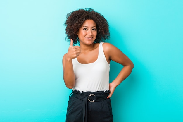 Giovane donna afroamericana che sorride e che alza il pollice in su