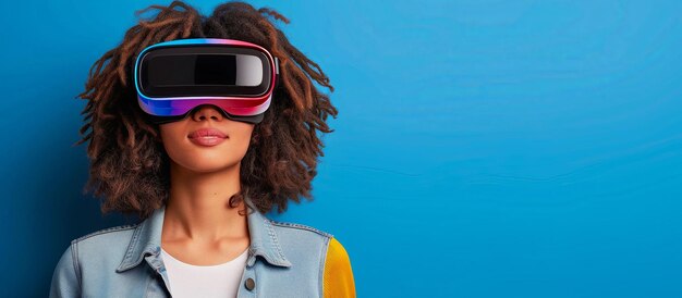 Giovane donna afroamericana con cuffie di realtà virtuale su sfondo blu con spazio di copia
