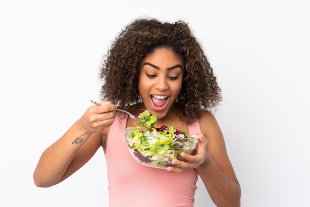 Giovane donna afroamericana con insalata isolata su spazio bianco