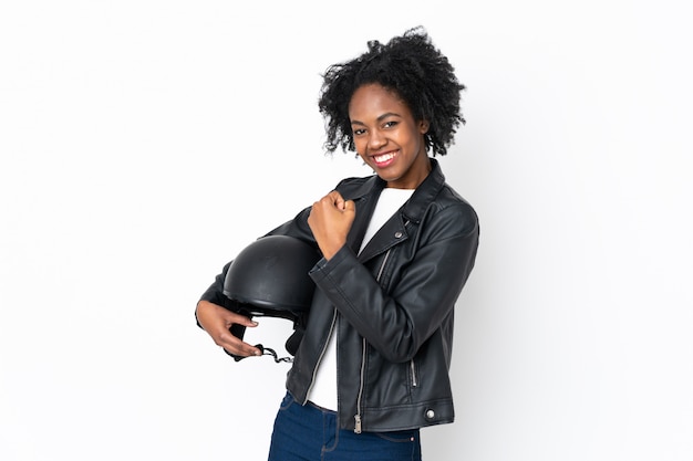 Giovane donna afroamericana con un casco del motociclo isolato su bianco