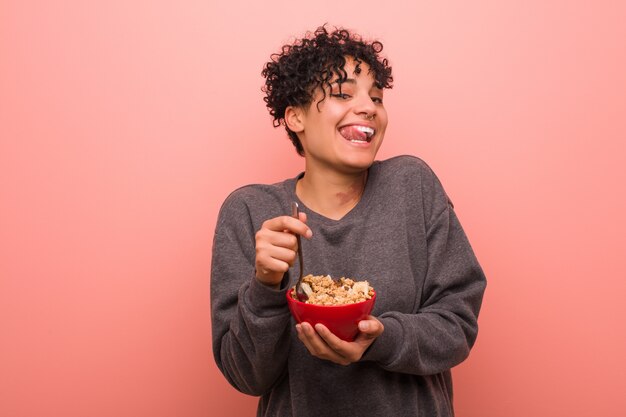 Giovane donna afroamericana con una voglia in possesso di una ciotola di cereali