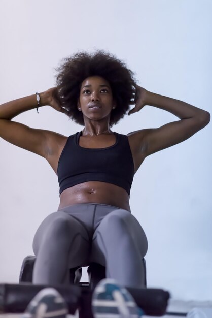 giovane donna afroamericana in forma che fa sit up in palestra presso la palestra. Esercizi addominali Siediti