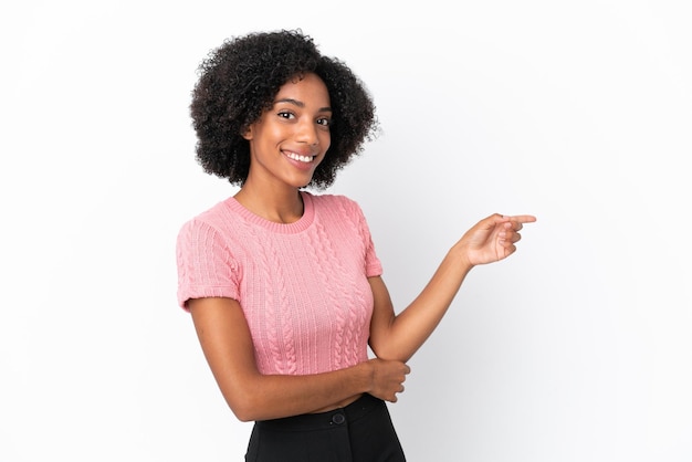 Giovane donna afroamericana isolata su sfondo bianco che punta il dito di lato