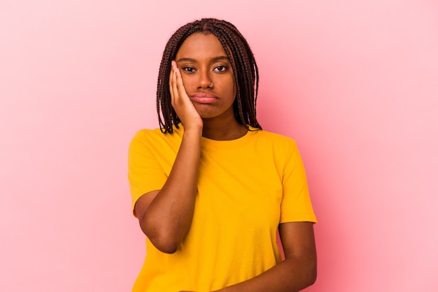Giovane donna afroamericana isolata su sfondo rosa che si sente triste e pensierosa, guardando lo spazio della copia.