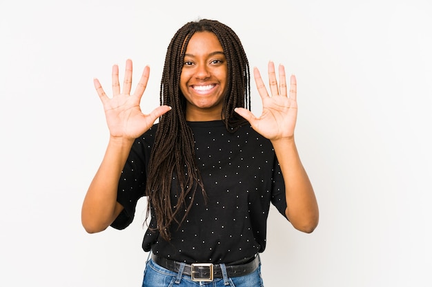 Giovane donna afroamericana isolata sul muro bianco che mostra il numero dieci con le mani.