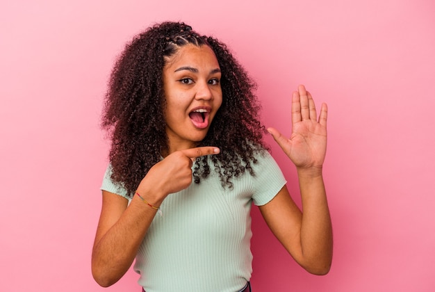 Giovane donna afroamericana isolata sul muro rosa sorridente allegro che mostra il numero cinque con le dita