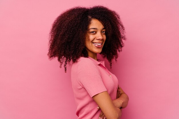 Giovane donna afroamericana isolata sul rosa felice, sorridente e allegra.