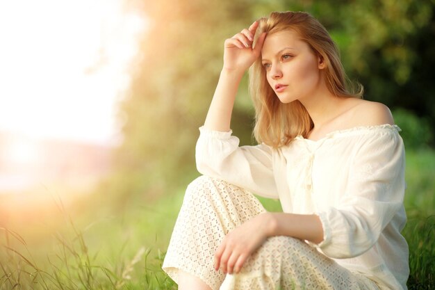 Giovane donna al tramonto vicino al fiume