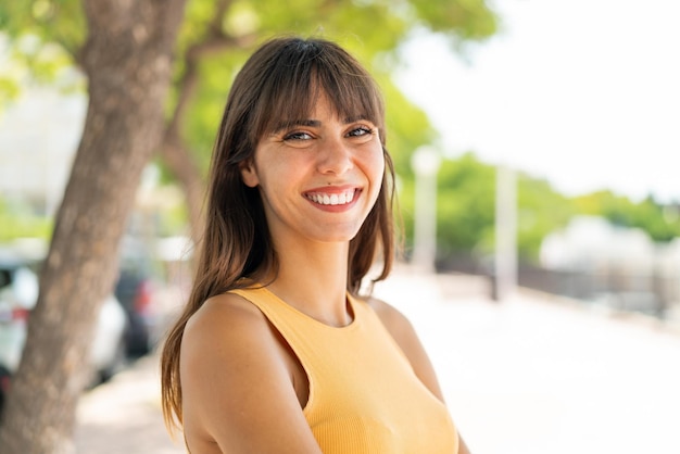 Giovane donna all'aperto con le braccia incrociate e guardando in avanti