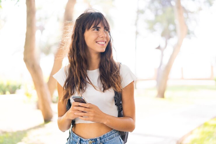 Foto giovane donna all'aperto utilizzando il telefono cellulare