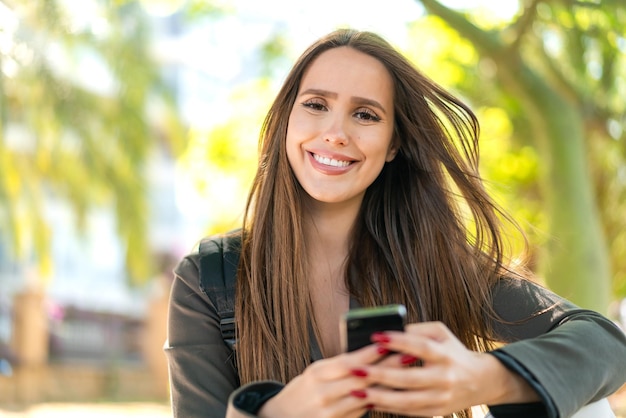 Giovane donna all'aperto utilizzando il telefono cellulare