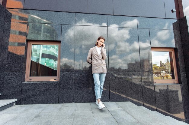 Giovane donna alla moda che parla al telefono in città