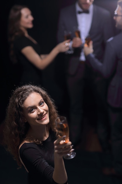 Giovane donna alla moda con un bicchiere di champagne