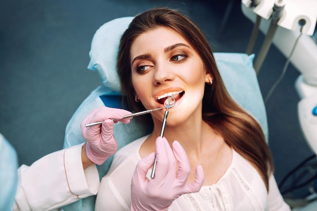 Giovane donna alla poltrona del dentista durante una procedura odontoiatrica Panoramica sulla prevenzione della carie dentale