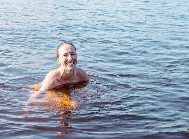 Giovane donna allegra che fa il bagno nel lago