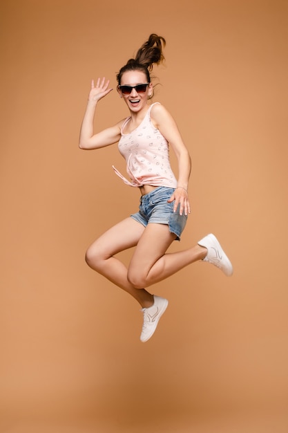 Giovane donna allegra del brunette nel salto casuale di prospettiva