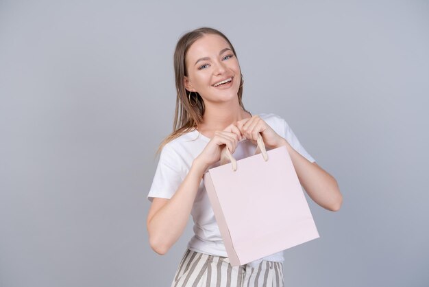 Giovane donna allegra felice sorriso positivo tenere il pacchetto della borsa acquistare la vendita del cliente