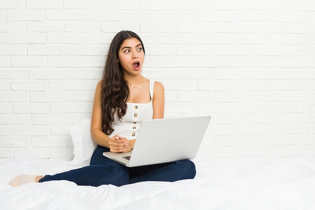 Giovane donna araba che lavora con il suo letto portatile, scioccato a causa di qualcosa che ha visto.