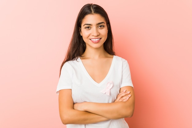 Giovane donna araba con un fiocco rosa. Concetto di lotta contro il cancro.