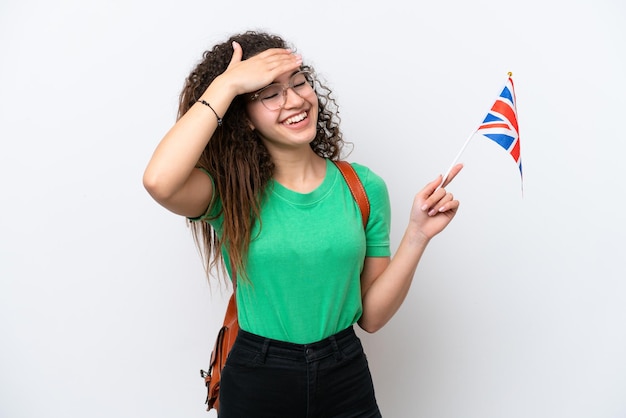 Giovane donna araba in possesso di una bandiera del Regno Unito isolata su sfondo bianco che sorride molto
