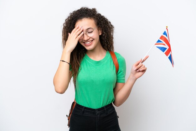 Giovane donna araba in possesso di una bandiera del Regno Unito isolata su sfondo bianco ridendo