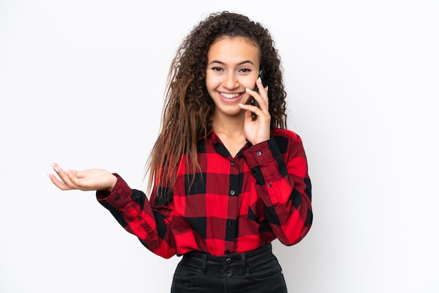 Giovane donna araba isolata su sfondo bianco mantenendo una conversazione con il telefono cellulare con qualcuno