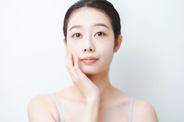 Giovane donna asiatica che controlla le condizioni della sua pelle