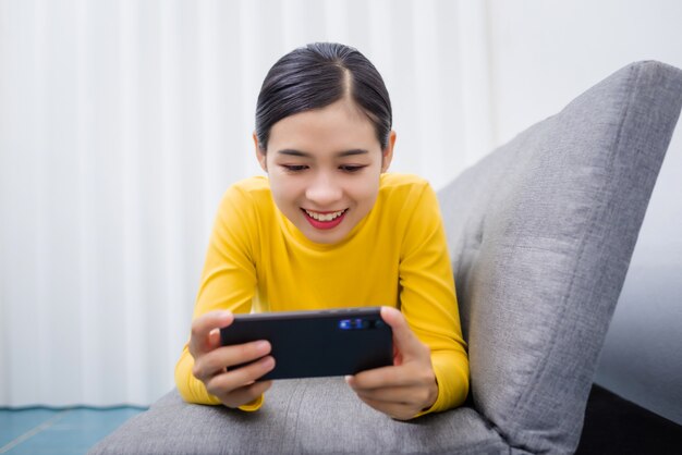 Giovane donna asiatica che guarda qualcosa sul cellulare