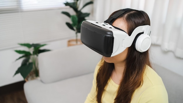 Giovane donna asiatica che indossa la realtà virtuale toccando l'aria durante l'esperienza VR Concetto di tecnologia futura