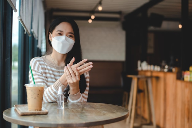 Giovane donna asiatica che indossa una maschera chirurgica per un nuovo stile di vita normale che vive in città urban