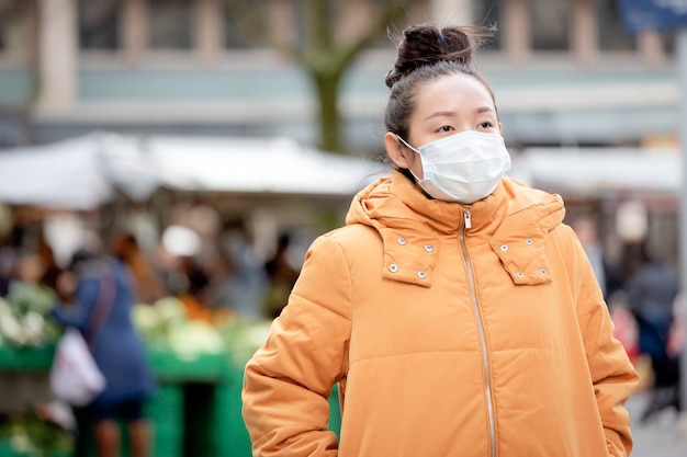 giovane donna asiatica che indossa una maschera per prevenire germi, fumi tossici e polvere