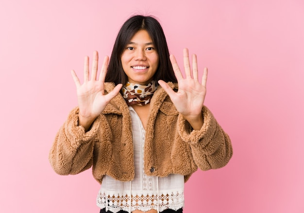 Giovane donna asiatica che mostra il numero dieci con le mani.