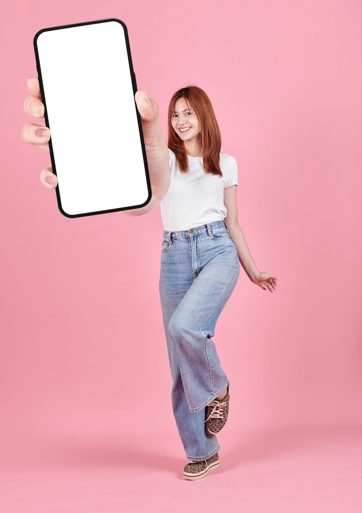 Giovane donna asiatica che mostra lo schermo bianco dello smartphone per la pubblicità delle app mobili isolata