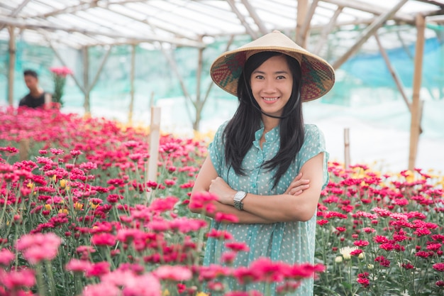 Giovane donna asiatica che raccoglie i fiori della camomilla