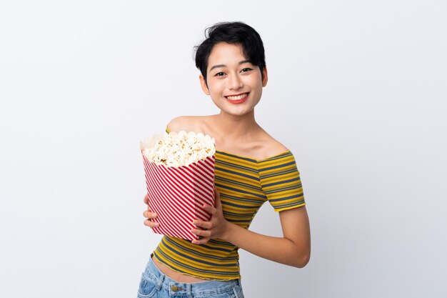 Giovane donna asiatica che tiene un grande secchio di popcorn