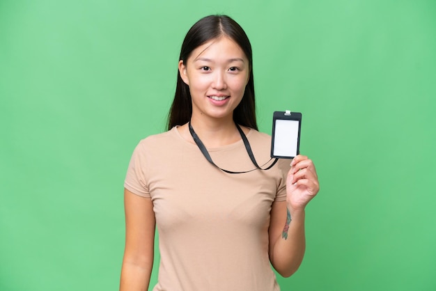 Giovane donna asiatica con carta d'identità su sfondo isolato sorridente molto