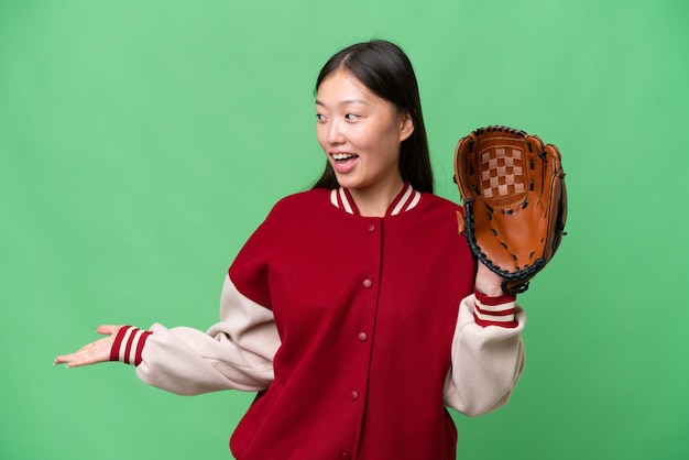 Giovane donna asiatica con guanto da baseball su sfondo isolato con espressione sorpresa guardando il lato