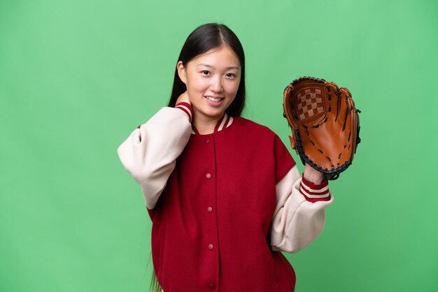 Giovane donna asiatica con guanto da baseball su sfondo isolato ridendo