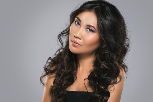 Giovane donna asiatica con i bei capelli ricci
