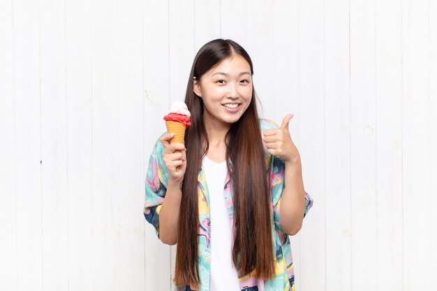 Giovane donna asiatica con un gelato isolato