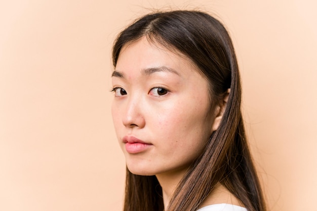 Giovane donna asiatica del ritratto isolata su fondo beige