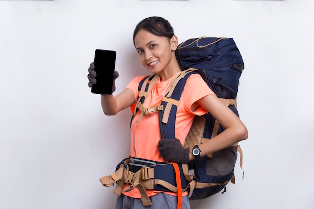 Giovane donna asiatica della viandante che mostra telefono cellulare isolato su fondo bianco