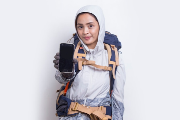 Giovane donna asiatica della viandante che mostra telefono cellulare isolato su fondo bianco