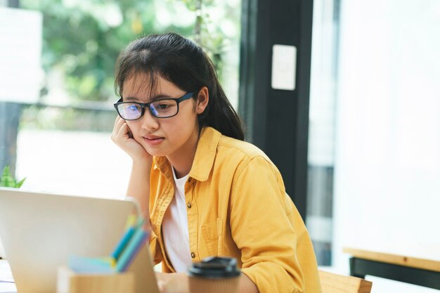 Giovane donna asiatica di affari o studente che lavora online sul computer portatile