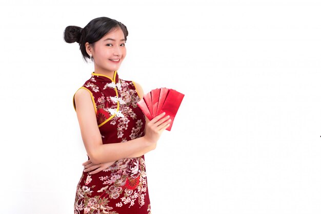 Giovane donna asiatica di bellezza che indossa cheongsam e che tiene pacchetto