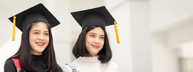 Giovane donna asiatica felice laureata in abito di laurea e berretto nel campus del college. Istruzione foto d'archivio